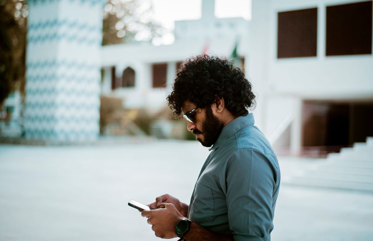 Person checking a local business on their phone while out in the street